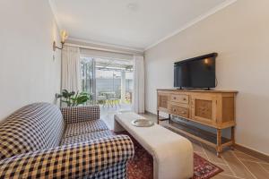 a living room with a couch and a tv at Lloyd's Corner in Cape Town