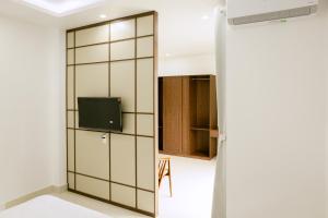a room with a sliding door with a tv at Cloud Inn Homestay in Thôn Lại Thê