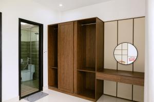 a bathroom with wooden cabinets and a mirror at Cloud Inn Homestay in Thôn Lại Thê +188 photos
