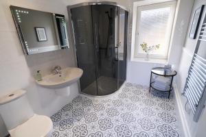 a bathroom with a shower and a toilet and a sink at Two Harbours Guest House in Scalpay +18 photos