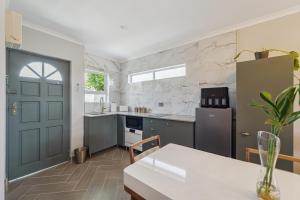 a kitchen with a table and a blue door at Lloyd's Corner in Cape Town