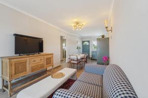 a living room with two couches and a flat screen tv at Lloyd's Corner in Cape Town +18 photos