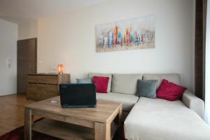 a living room with a couch and a table with a laptop at Apartment Butterfly in Osijek