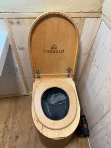 a toilet with a wooden seat in a small room at Lovingly renovated 120-year-old train car! in Ramsau am Dachstein
