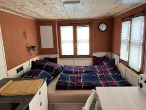 a room with two beds and a clock on the wall at Lovingly renovated 120-year-old train car! in Ramsau am Dachstein