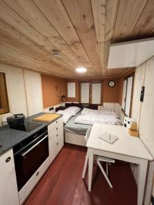 a small kitchen with a bed in a room at Lovingly renovated 120-year-old train car! in Ramsau am Dachstein +10 photos