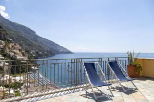 a balcony with two chairs and a view of the ocean at Hotiday Positano Sea View in Positano