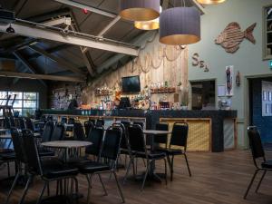 a bar with tables and chairs in a restaurant at 88, Two bed Chalet on Belle Aire Holiday Park - sleeps 5, pet friendly, bed linen and towels included plus onsite entertainment available in Great Yarmouth