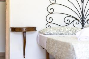 a bed with a black iron headboard next to a table at Hotiday Positano Sea View in Positano