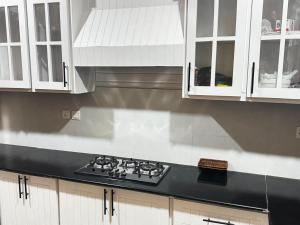 a kitchen with white cabinets and a stove top at Pent House Executive Resedency in Dargai +3 photos