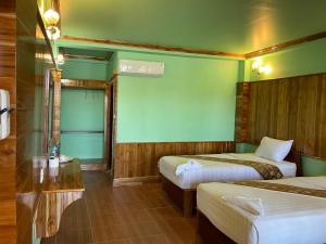 a hotel room with two beds and a screen at Pan guest house Donkhone in Ban Donsôm