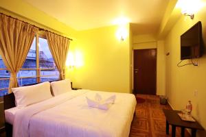 My Hotel Pvt Ltd tesisinde bir odada yatak veya yataklar