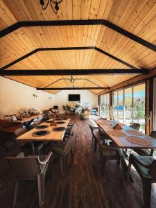 a large dining room with wooden ceilings and tables and chairs at La Poalele Vulcanilor in Densuş