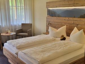 a hotel room with two beds and a chair at Hotel Walkenstein in Oberwolfach