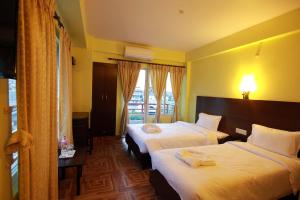 My Hotel Pvt Ltd tesisinde bir odada yatak veya yataklar