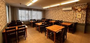 a restaurant with wooden tables and chairs in a room at Suurlahe Guesthouse in Kuressaare +28 photos