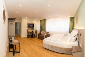 a bedroom with a bed and a living room at Living Inn am Schlosspark - Zentral, Parkplatz und Kitchenette in Rheda-Wiedenbrück