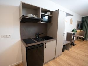 a small kitchen with a sink and a microwave at Living Inn am Schlosspark - Zentral, Parkplatz und Kitchenette in Rheda-Wiedenbrück +35 photos