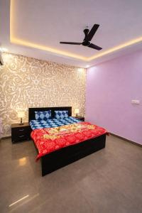 a bedroom with a bed and a ceiling fan at Drop Hills Farm Noida in Noida