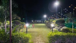 a garden at night with chairs and lights at Drop Hills Farm Noida in Noida