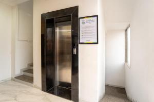 a elevator in a building with a sign on the wall at Treebo Shridhar Stay, 2 km from Indore Junction in Indore +18 photos