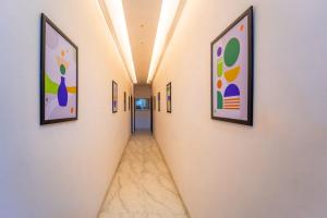 a corridor of a hallway with paintings on the walls at Treebo Shridhar Stay, 2 km from Indore Junction in Indore