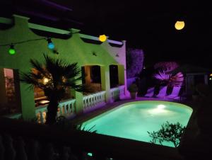 a house with a swimming pool at night at Appartement Sole e Mare in Furiani