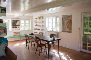 a dining room with a wooden table and chairs at Guest house Æbelnæs, Møn in Stege