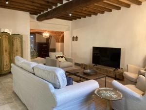 a living room with white furniture and a flat screen tv at Appartamento Monache in Lucignano