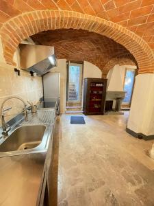 a kitchen with a sink and a brick wall at Appartamento Monache in Lucignano +10 photos