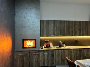 a kitchen with a stove with a fire on the counter at Green Wood in Azuga +19 photos