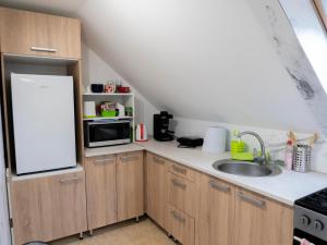a kitchen with a white refrigerator and a sink at Katyca Apartman in Balatonfüred +4 photos