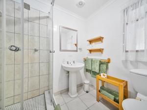 a bathroom with a toilet sink and a shower at Pumula Lodge 4 Star Guesthouse Knysna in Knysna