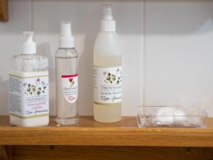 three bottles of milk sitting on a wooden shelf at Pumula Lodge 4 Star Guesthouse Knysna in Knysna