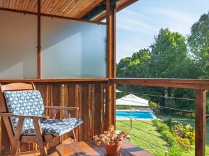 a rocking chair on a screened porch with a view at Pumula Lodge 4 Star Guesthouse Knysna in Knysna +69 photos