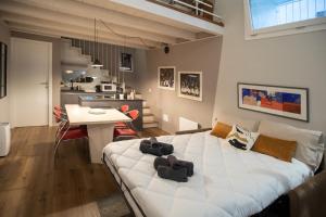 a bedroom with a large white bed and a kitchen at Casa degli Specchi- Duplex in Arona city center - By Guestaly in Arona