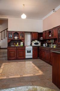 a large kitchen with wooden cabinets and white appliances at Whispering Trees in Kandy