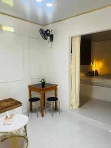 a room with a bed and two chairs and a table at Mercy Cottage in Langgur