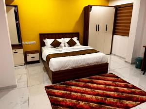 a bedroom with a large bed and a rug at Nice Inn Residency in Kozhikode