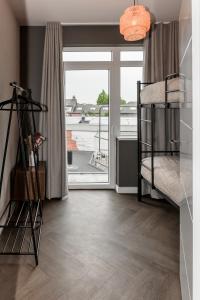 a bedroom with a bunk bed and a window at Slapen bij van O 2 in Yerseke