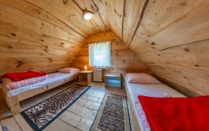 um quarto com duas camas num chalé de madeira em Domki na Stoku em Ustrzyki Dolne
