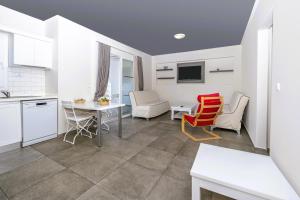 a kitchen and living room with a table and chairs at Muskebi Apart Otel in Ortakent