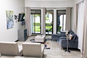 a living room with a couch and chairs and a tv at Sigelege Beach Resort in Senga