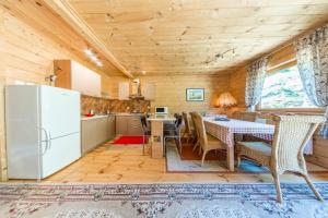 uma cozinha com uma mesa e cadeiras e um frigorífico em Domki na Stoku em Ustrzyki Dolne