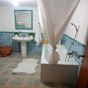 a bathroom with a bath tub and a sink at Amadrias Villa Florina in Florina