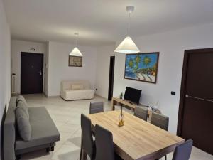 a dining room and living room with a table and chairs at mirosa airport home in Macchie