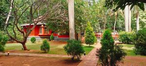 a house in the middle of a garden with trees at Sun Private Pool Villa in Puducherry Airpoert