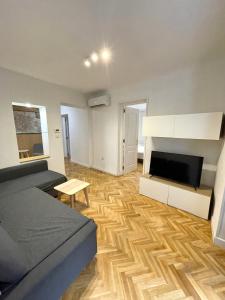 a bedroom with a bed and a television and a wooden floor at Apartamentos Mayor Centro in Madrid