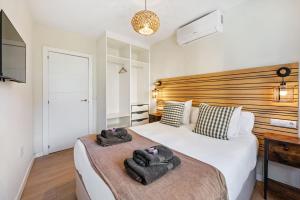 a bedroom with a large bed with two towels on it at VICTORIA 75 LUXURY in Málaga +39 photos
