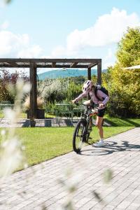 a young girl riding a bike on a sidewalk at Ca' San Matteo in Tesserete
